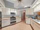 Well-lit kitchen featuring tile floors, stainless steel appliances and ample cabinet space at 13094 Huntington Woods Ave, Spring Hill, FL 34609