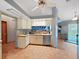 Charming kitchen features stainless steel dishwasher, cream cabinetry, and an eat-in breakfast area at 13094 Huntington Woods Ave, Spring Hill, FL 34609