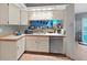 Cozy kitchen featuring ample counter space, stainless steel dishwasher and natural lighting at 13094 Huntington Woods Ave, Spring Hill, FL 34609