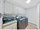 Convenient laundry room equipped with modern washer, dryer, and ample storage cabinets at 13094 Huntington Woods Ave, Spring Hill, FL 34609
