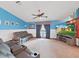 Relaxing living room featuring a leather sofa, ceiling fan, and neutral carpet at 13094 Huntington Woods Ave, Spring Hill, FL 34609