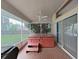 Enclosed patio with ceiling fan and hot tub looking out to the backyard at 13094 Huntington Woods Ave, Spring Hill, FL 34609