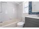 Bright bathroom featuring a shower-tub combo, blue accent tiles, and a modern vanity at 13377 Elise Ln, Spring Hill, FL 34609