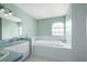 Relaxing bathroom featuring a built-in bathtub, double vanity, and serene decor at 13377 Elise Ln, Spring Hill, FL 34609