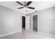Well-lit bedroom with tile floors, a ceiling fan, and multiple doorways to closets and other rooms at 13377 Elise Ln, Spring Hill, FL 34609