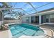 Gorgeous screened pool with a waterfall feature and a spacious outdoor patio at 13377 Elise Ln, Spring Hill, FL 34609