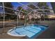 Outdoor screened pool area features a rock waterfall, patio, and beautiful backyard views at 13377 Elise Ln, Spring Hill, FL 34609