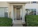 Inviting townhouse front door with columns, lush greenery, and a well-maintained entrance at 13521 Forest Lake Dr, Largo, FL 33771