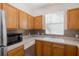 Bright kitchen boasting stainless steel appliances, light wood cabinets, and mosaic tile backsplash at 13521 Forest Lake Dr, Largo, FL 33771