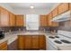Traditional kitchen featuring wooden cabinets, mosaic tile backsplash, and white appliances at 13521 Forest Lake Dr, Largo, FL 33771