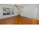 Bright living room features wood floors, large window, ceiling fan and access to a restroom at 13521 Forest Lake Dr, Largo, FL 33771