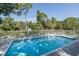 Community pool offers a refreshing escape with lounge chairs and clear blue water surrounded by trees at 13521 Forest Lake Dr, Largo, FL 33771