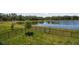 Picturesque backyard with lush lawn, wrought iron fence, and a serene pond view, creating a private oasis at 14439 Woodland Spur Dr, Lithia, FL 33547