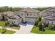 Elegant two-story home with a three-car garage, neutral stucco, and manicured lawn in a desirable neighborhood at 14439 Woodland Spur Dr, Lithia, FL 33547