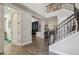 Elegant foyer featuring a staircase with iron railings and views into the home office and dining area at 14439 Woodland Spur Dr, Lithia, FL 33547
