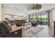 Open living room features leather furniture, a stylish ceiling fan, and sliding doors to the outdoor space at 14439 Woodland Spur Dr, Lithia, FL 33547