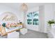 Bright bedroom with a hello wall decoration, stylish bamboo style furniture, and a sunlit window at 1576 Valier Pt, Zephyrhills, FL 33541