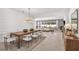 Elegant dining room with a long wooden table, modern chandelier, and seamless flow to the living area at 1576 Valier Pt, Zephyrhills, FL 33541