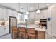 Modern kitchen with white cabinets, stainless steel appliances, quartz countertops, and breakfast bar at 1576 Valier Pt, Zephyrhills, FL 33541