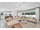 Spacious living room with neutral tones, stylish chandelier, and sliding glass doors to the backyard at 1576 Valier Pt, Zephyrhills, FL 33541