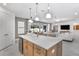 Open-concept kitchen and living area featuring large windows, modern lighting, and stylish furniture at 1576 Valier Pt, Zephyrhills, FL 33541