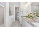 Bright main bathroom featuring a double vanity, granite countertop, and a walk-in shower with glass door at 1576 Valier Pt, Zephyrhills, FL 33541