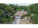 Aerial view showing the house with an attached garage, complemented by a well-maintained lawn and mature trees at 1617 Dawnridge Ct, Brandon, FL 33510