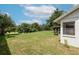 Backyard view featuring a spacious lawn with mature trees and a screened-in patio at 1617 Dawnridge Ct, Brandon, FL 33510