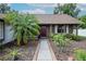 Charming home exterior with a palm tree, well-manicured landscaping and covered front entrance at 1617 Dawnridge Ct, Brandon, FL 33510