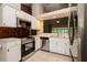 Well-lit kitchen with stainless steel appliances, white cabinets, and tile flooring, offering functionality at 1617 Dawnridge Ct, Brandon, FL 33510