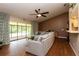 Bright living room featuring a ceiling fan, wood floors, and a cozy gray sectional couch at 1617 Dawnridge Ct, Brandon, FL 33510