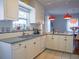 Bright kitchen featuring white cabinets, granite counters, pendant lights, and a view into the dining area at 1620 15Th N St, St Petersburg, FL 33704