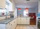 Bright kitchen featuring white cabinets, granite counters, pendant lights, and a view into the dining area at 1620 15Th N St, St Petersburg, FL 33704
