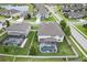 Overhead shot of a home with a screened-in pool and a landscaped lawn and community at 18696 Malinche Loop, Spring Hill, FL 34610