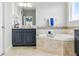 Elegant bathroom featuring a soaking tub, dark cabinetry, and decorative tile accents at 18696 Malinche Loop, Spring Hill, FL 34610