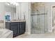 Stylish bathroom with a glass-enclosed shower, dark cabinetry, and a soaking tub at 18696 Malinche Loop, Spring Hill, FL 34610