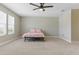 Large bedroom features neutral carpet, a ceiling fan and two windows at 18696 Malinche Loop, Spring Hill, FL 34610