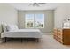 Bright bedroom with neutral carpet, a ceiling fan, two windows, and a wooden dresser at 18696 Malinche Loop, Spring Hill, FL 34610