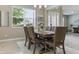 Formal dining room featuring a wooden table, six chairs, modern light fixture and large window at 18696 Malinche Loop, Spring Hill, FL 34610