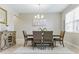 Formal dining room featuring a wooden table, six chairs, modern light fixture and large window at 18696 Malinche Loop, Spring Hill, FL 34610