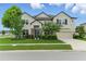 Inviting two-story home with manicured landscaping, a three-car garage, and stone accents at 18696 Malinche Loop, Spring Hill, FL 34610