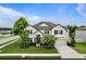 Charming two-story home with a well manicured lawn, flowering trees and a paved driveway at 18696 Malinche Loop, Spring Hill, FL 34610