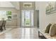 Bright foyer with a decorative front door, neutral tile flooring, and tall ceilings at 18696 Malinche Loop, Spring Hill, FL 34610
