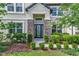 Stunning front entrance with stone accents, a decorative glass door, and meticulously maintained landscaping at 18696 Malinche Loop, Spring Hill, FL 34610