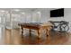 Game room featuring a wooden pool table, hardwood floors, and television at 18696 Malinche Loop, Spring Hill, FL 34610