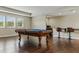 Open game room featuring a pool table with an adjacent wet bar and hardwood floors at 18696 Malinche Loop, Spring Hill, FL 34610