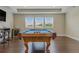 Game room with a pool table, wood floors, and ample natural light from the windows at 18696 Malinche Loop, Spring Hill, FL 34610
