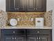 Close up shot of modern, dark kitchen cabinetry with stainless steel appliances and tile backsplash at 18696 Malinche Loop, Spring Hill, FL 34610