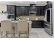 Modern kitchen featuring dark cabinets, stainless steel appliances, tile backsplash, and island seating at 18696 Malinche Loop, Spring Hill, FL 34610