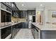Modern kitchen featuring dark cabinets, stainless steel appliances, granite countertops, and island seating at 18696 Malinche Loop, Spring Hill, FL 34610